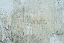 The Surface Of A Concrete Wall With Old Peeling Paint. The Texture Of Time-damaged Paint. Multi-colored Blank Background For The Design.