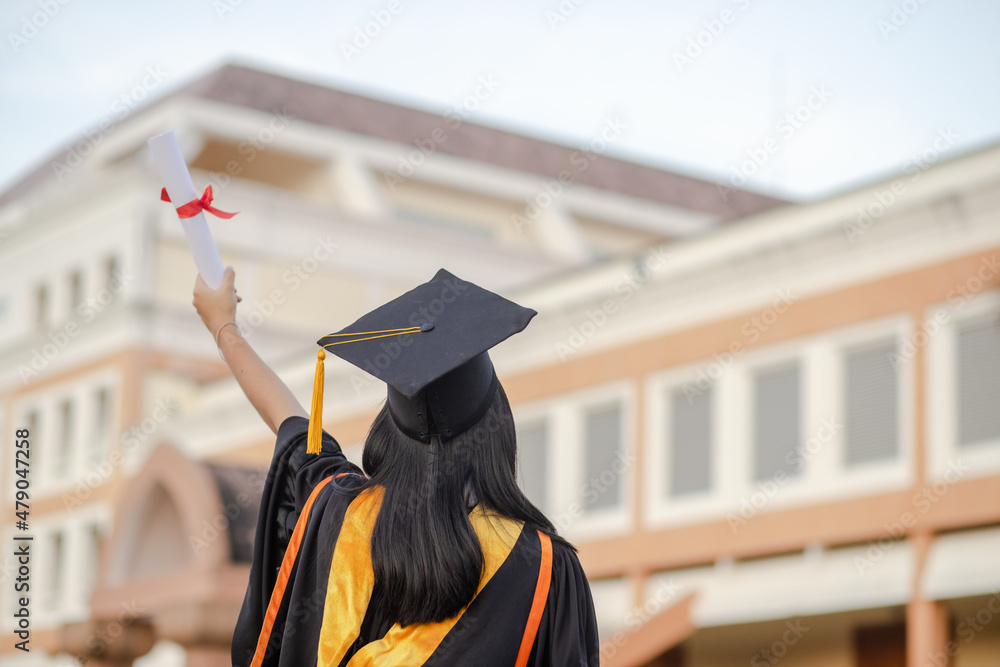 Graduates raise their hands to celebrate graduation with diplomas and ...