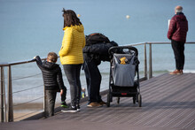Family With Baby Carriage, Looking At The Sea