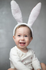 Portrait of a cute 1 year old baby dressed in the ears of an Easter bunny