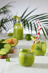 Wall Mural - two glasses of vegan detox green smoothie on a white table