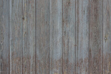 An Old Fence Made Of Vertically Assembled Boards. Background, Texture.