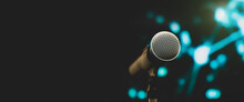Microphone Public Speaking Background, Close Up Microphone On Stand For Speaker Speech Presentation Stage Performance With Blur And Bokeh Light Background.