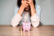 © Zhanna - Sad girl with a crying piggy bank.