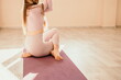 © panophotograph - Young sporty woman, fitness instructor in pink sportswear doing stretching and pilates on yoga mat in the studio with mirror. Female fitness yoga routine concept. Healthy lifestyle and harmony.