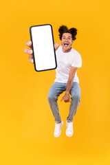 Wall Mural - Man showing white empty smartphone screen and jumping