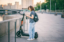 Young Happy Woman Renting Scooter Using Mobile App In Smartphone, Modern Transport In Big City