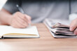 © NongAsimo - Close up newspaper pile with hand a man and write on the book : reading information in the daily newspaper