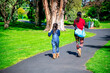 © jovannig - Mother and daughter walking along a beautiful city park on a sunny day, back view.