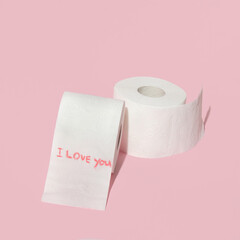 Valentines day creative layout with toilet paper rolls and handwritten message I love you on pastel pink background. 80s or 90s retro fashion aesthetic love concept. Minimal romantic idea.