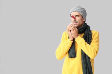 Poster - Ill young man with clothespin on his nose against grey background