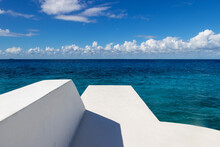 White Diving Pier Over Vibrant Blue Caribbean Sea Water On The Tropical Island Of Cozumel