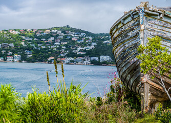 A rustic boat on Knysna lagoon and the heads mountain village