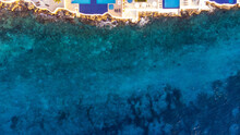 Aerial View Captured By Drone Of Vibrant Blue Swimming Pools Along The Rocky Shore Of Cozumel, Mexico In Quintana Roo As The Turquoise Ocean Water Of The Caribbean Sea Is Clear To Display Coral Reefs.