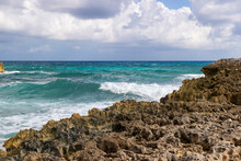 Vibrant Turquoise Blue Ocean Water With Waves Crashing On The Limestone Rocky Shore Of Cozumel, Mexico