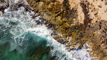 Aerial View Captured By Drone Showing The Power Of The Caribbean Sea Waves. The Ocean Water Crashes Into The Limestone Shore On The Beach Of Tropical Island Cozumel, Mexico In Quintana Roo.