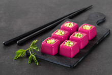 Beetroot Cream Jelly In The Form Of Small Portions Of A Square Shape With A Filling Of Finely Chopped Egg With Parsley On A Serving Board On A Dark Gray Background