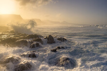 Seascape. Waves Beating Against The Rocks In Quintanilla Beach At Sunset. Arucas. Canary Islands