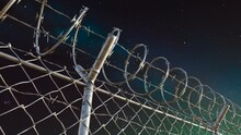 Endless View At The Top Of Prison Or Airport Fence On Night Sky Background. 4kHD