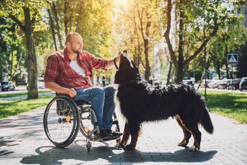 Wall Mural - Happy young man with a physical disability who uses wheelchair with his dog.