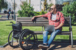 © romaset - Freelancer with a physical disability who uses wheelchair working at the park