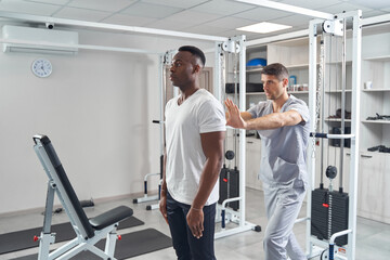 Wall Mural - Qualified physiatrist examining spine of young man