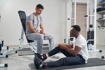 Wall Mural - Focused physiatrist listening to male patient complaints