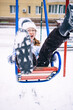 © Анна Молько - child playing in the playground.  happy children in winter coat on a wings.