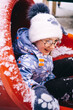 © Анна Молько - child playing with snow. happy children on a slide. girl in white hat and winter coat