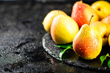 Ripe Pears With Leaves On A Stone Board. On A Black Background. High Quality Photo