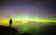 silhouette of a person in front of Northern lights. 