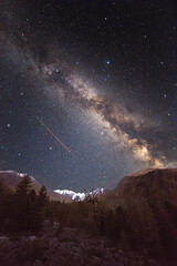 Wall Mural - starry sky and milky way over mountains. flying meteor. super wide angle. a large number of small st