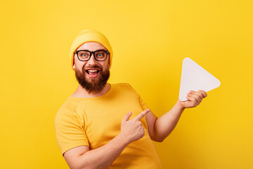 smiling man pointing at play button sign over yellow background, technology, media player button