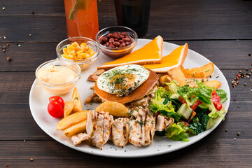 Canvas Print - Big breakfast plate with sausage, scrambled eggs, baked beans, bacon, mushrooms and other condiments