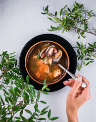 Poster - Hand holding a spoon with a shrimp and fish, Seafood Diet soup