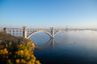 Zaporozhye, Ukraine. Preobrazhensky Bridge in autumn colors. Blue sky and the river Dnipro