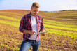 © Kaspars Grinvalds - Farmer standing in field and using digital tablet