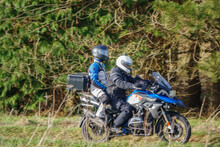 Motorbike Rider And Pillion Passenger On A BMW R1200 GS Motorcycle Travelling Through Winter Countryside