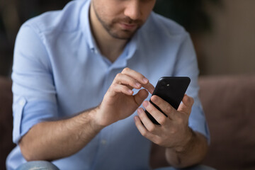 Wall Mural - cropped close up man using smartphone, typing on screen, focus on modern phone in male hands, chatti