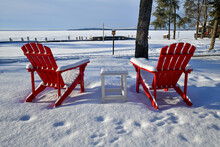 Empty Red Lawn Chairs In Winter Snow
