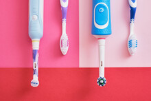 Different Toothbrushes On Pink Background, Electric Toothbrush Or Plastic Toothbrush