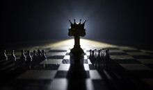 Chess Board Game Concept Of Business Ideas And Competition And Strategy Ideas Concep. Chess Figures On A Dark Background With Smoke And Fog And Window With Sunlight. Selective Focus