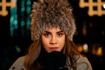 Closeup shot , portrait of young woman with nose piercing with winter fur hat 