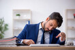 © Elnur - Young male employee extremely tired in the office
