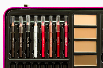 Close-up of a make-up case with eyeliner pencil, lip liner and compact foundation cream.