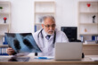 © Elnur - Old male doctor radiologist working in the clinic