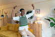 © Westend61 - Cheerful woman dancing and listening through headphones at home