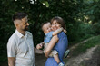 © Westend61 - Happy mother embracing son standing by man at park