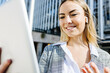 © Westend61 - Smiling young businesswoman on video call through tablet PC