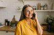 © shurkin_son - Smiling senior female talking on mobile phone to son or daughter with happy facial expression. Emotional talk to family, keep contact on distance, relationship, growing old concept